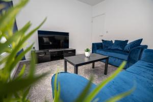 a living room with blue couches and a coffee table at Bright Key Stays - The Lincoln Lodge at Spa Street in Lincoln