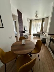 Una sala de estar con una mesa y sillas y un sofá. en AMB Luxury Residence Pipera, en Voluntari