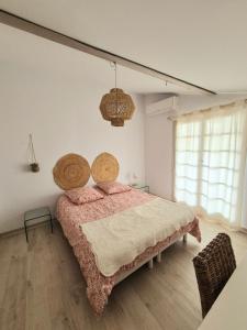 a bedroom with a bed and a large window at Appartement T2, proche plage, climatisé et parking privé in Saintes-Maries-de-la-Mer