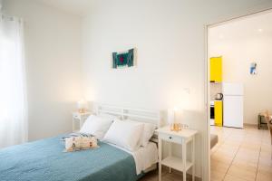 een witte slaapkamer met een bed en een spiegel bij Bella Apartment in Chania