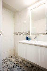 een badkamer met een bad, een wastafel en een spiegel bij Bella Apartment in Chania