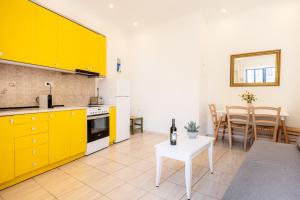 een keuken met gele kasten en een tafel. bij Bella Apartment in Chania +9 foto's