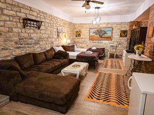 a living room with a couch and a stone wall at Hotel Taraca Gorice - UNESCO quarter in Berat