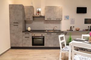 巴里Dimora serafino的带炉灶的厨房 桌子旁的顶部烤箱