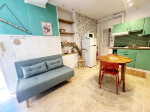 a kitchen with a blue couch and a table at La Casa di Via Nervi in Ladispoli