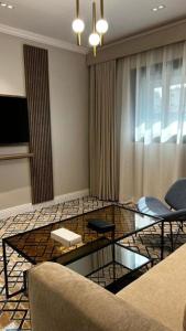 a living room with a glass table and chairs at فندق فاتوران vatoran hotel in Al Madinah