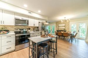 a kitchen with white cabinets and a table with bar stools at Lovely Secluded Cabin Surrounded by Trees in Clarkesville, Georgia in Aerial
