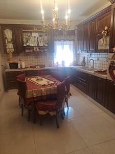 Una cocina con mesa y sillas y una cocina con ventana. en Luxury House, en Catania