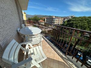 two white chairs and a table on a balcony at Casa Deodato in Diano Marina