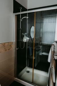 una doccia con una porta in vetro in un bagno di Dawn Break Guest House a Largs Altre 13 foto