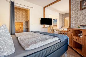 a bedroom with a bed and a television in it at Ferienzimmer auf Der Insel Rügen in Sagard