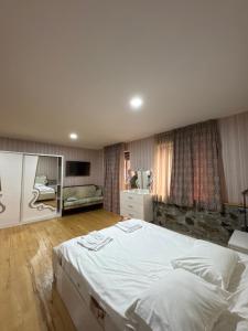 a bedroom with a large white bed and a couch at Svaneti in Lentekhi