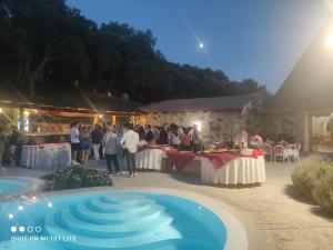 a group of people standing around a table at a party at Fratelli muzzu in Piras
