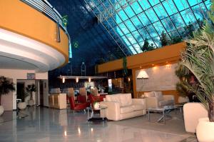 a lobby with couches and chairs in a building at Hotel Solarium Express in Cambé