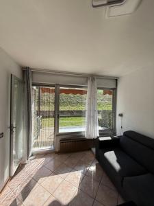 a living room with a couch and a large window at AlpinVista- Le Maddalene in Cavareno