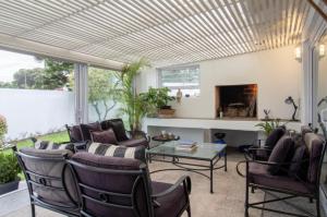 a living room with a couch and chairs and a fireplace at Pletts Seaside Gem in Plettenberg Bay