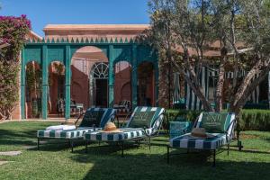 a group of beds in the grass in front of a building at Luxurious Villa with private pool - Kasbah Conti in Marrakesh