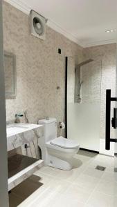 a bathroom with a toilet and a sink at فندق فاتوران vatoran hotel in Al Madinah