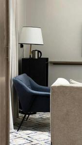 a living room with a blue chair and a lamp at فندق فاتوران vatoran hotel in Al Madinah