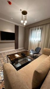 a living room with a couch and a glass table at فندق فاتوران vatoran hotel in Al Madinah