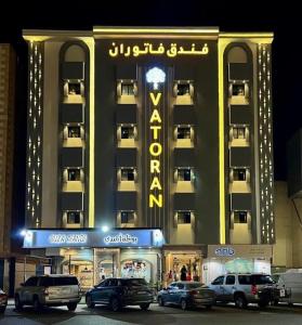 a large building with cars parked in front of it at فندق فاتوران vatoran hotel in Al Madinah