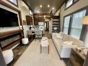 a living room with a couch and a table at Breathtaking Tiny House Settled Between Trees in Tracy City, Tennessee in Tracy City