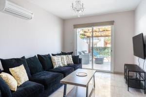 a living room with a black couch and a table at Carisa flat, 2 bedrooms in Larnaca
