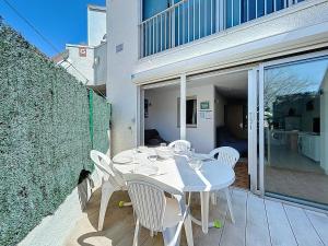 a white table and chairs sitting on a patio at 3683-Appartement en front de mer in Saint-Cyprien-Plage