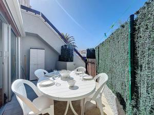 a white table and white chairs on a balcony at 3683-Appartement en front de mer in Saint-Cyprien-Plage