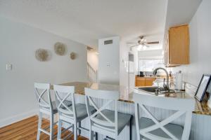 a kitchen with a white counter and a bar with stools at Less Than Half Mi to Gulf Biloxi Condo with Patio! in Biloxi