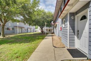 a sidewalk in front of a building with trees at Less Than Half Mi to Gulf Biloxi Condo with Patio! in Biloxi