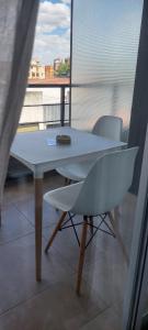 a white table and chairs in a room with a window at Rentarte in Pilar