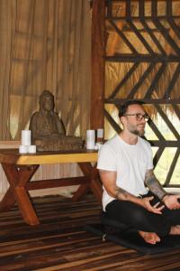 エル・ザイノにあるSenda Loto Retreat Meditation Yogaの床に座る男