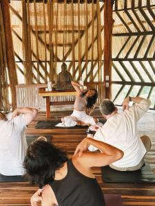 エル・ザイノにあるSenda Loto Retreat Meditation Yogaの像のある部屋でヨガをする集団