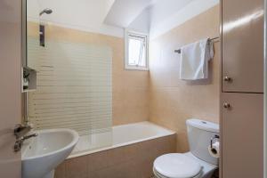 a bathroom with a toilet and a tub and a sink at Carisa flat, 2 bedrooms in Larnaca +4 photos
