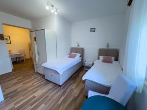 een kamer met 2 bedden en een bureau bij Apartments Marin Tomas in Dubrovnik