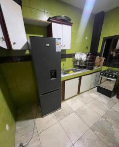 a kitchen with a refrigerator and a stove in it at Beauty home Douala ndogbong in Douala