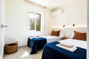 una stanza con due letti e una finestra di Villa Gabriel by Escapehome a Son Bou Altre 20 foto