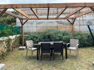 un tavolo nero con sedie sotto un pergolato in legno di Derya Beach Ağullu Villa 2 a Kaş