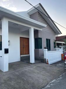 a white house with a brown door in a driveway at Homestay Haji Ismail selayang 2025 mvslim only 3R2B in Batu Caves