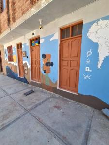 a wall with a mural of doors and a world at Backpacker hostal oruro in Oruro