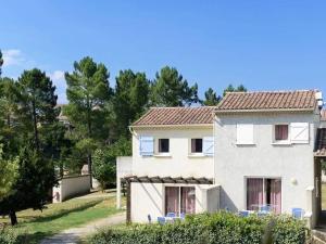a white house with blue chairs in front of it at Maison Duplex avec Terrasse, 2 Chambres, Piscines et Parking - FR-1-382-19 in Salavas
