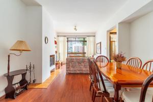 ein Esszimmer und ein Wohnzimmer mit einem Holztisch in der Unterkunft Lindo Apto no Centro de Serra Negra in Serra Negra