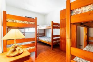 Zimmer mit 4 Etagenbetten und einer Lampe auf dem Tisch in der Unterkunft Lindo Apto no Centro de Serra Negra in Serra Negra + 37 Fotos