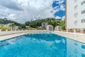 ein großes Schwimmbad neben einem Gebäude in der Unterkunft Lindo Apto no Centro de Serra Negra in Serra Negra