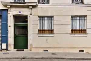 een groene deur op een gebouw met ramen bij Amelie in Paris in Parijs