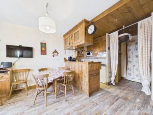 a kitchen and dining room with a table and chairs at Charmant 3P Centre Station avec Parking et TV - FR-1-398-559 in La Rosière