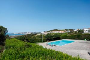 a swimming pool with a view of the ocean at Serene View - By SCH in Alvados