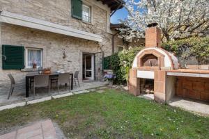 a backyard with a brick pizza oven in the yard at Il Giardino Segreto Sulzano in Sulzano