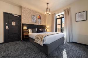 a bedroom with a large bed and a large window at Abel Heywood Boutique Hotel in Manchester